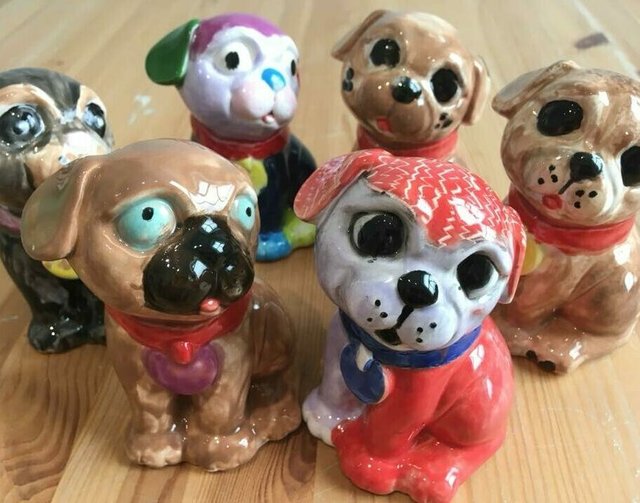 Six ceramic pug figurines.