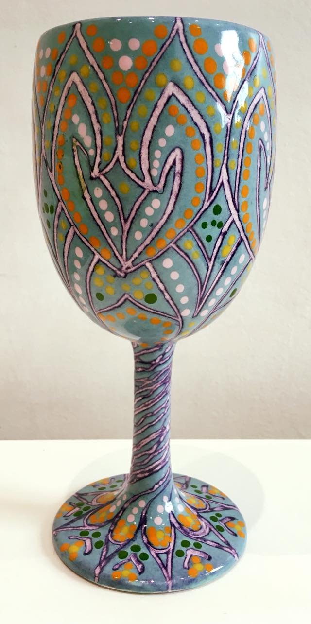 Blue ceramic cup with purple stem and decorative swirls.