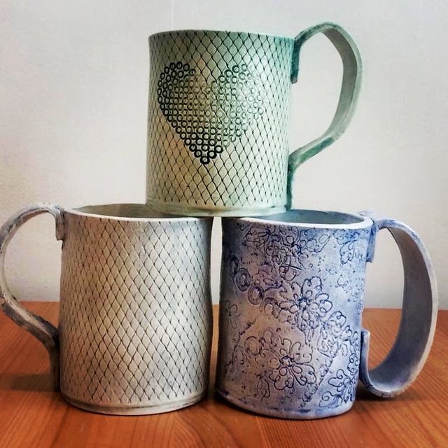 Three ceramic mugs with textured designs.